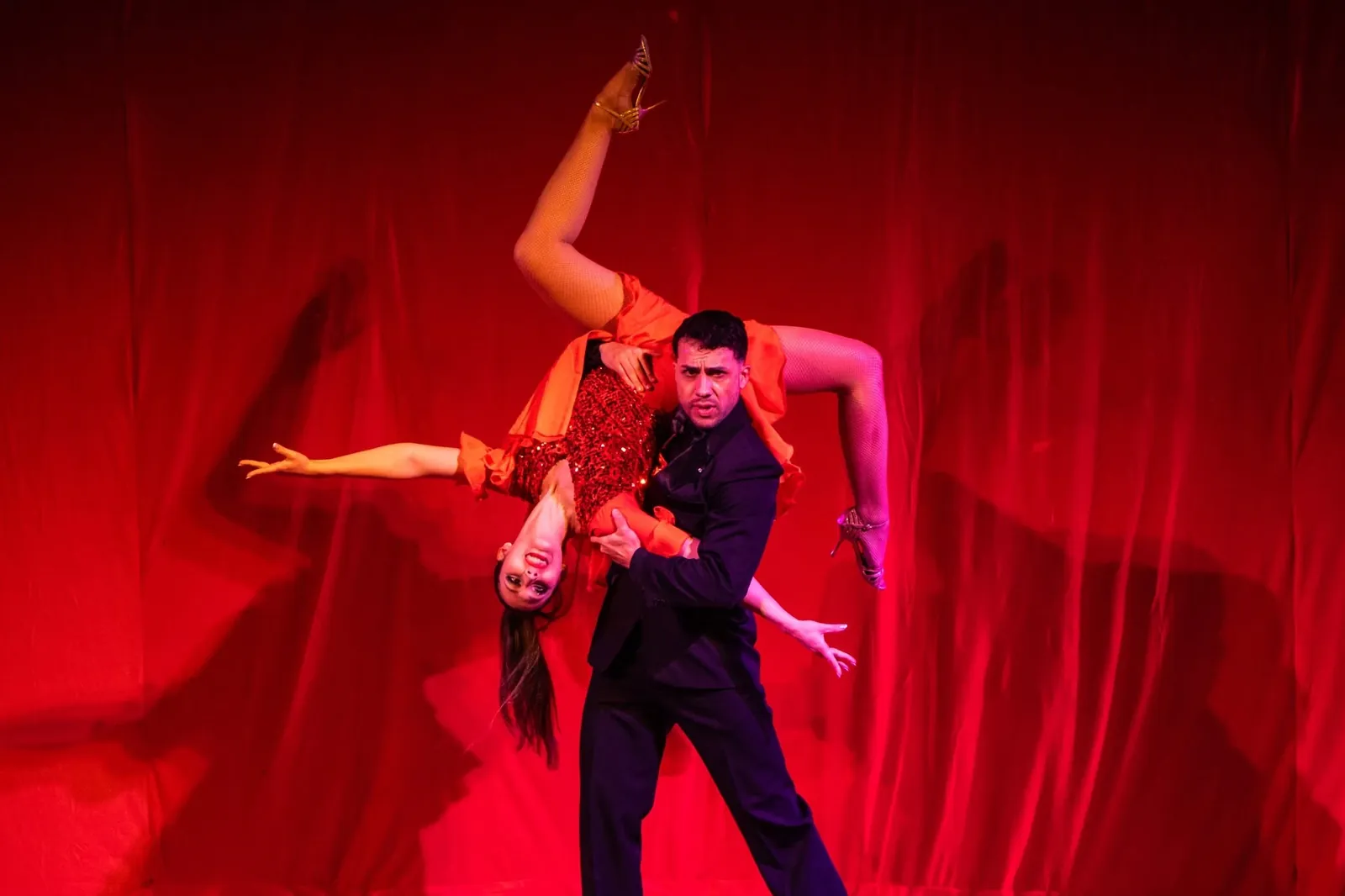 Pareja de baile acrobático sobre fondo rojo